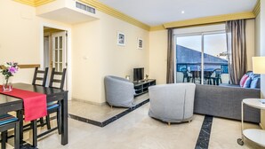 A modern living room with a dining area, a sofa, and a TV. - Apartamento en Marbella con vistas laterales al mar 328 (Marbella)