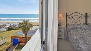 Quarto com vista para a praia e oceano.