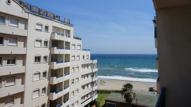 Um hotel com vários andares e varandas com vista para a praia.