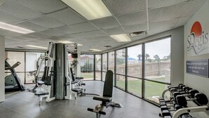 Un gimnàs amb equipament esportiu, una banca i una barra de peses.