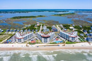 A coastal resort with high-rise buildings, a beach, and a marina.