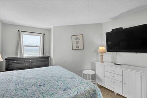 A bedroom with a bed, a dresser, a television, and a window with curtains. - Top Floor, eagle eye views of The Atlantic! Tons of amenities (North Topsail Beach)