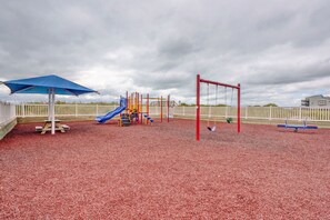 A playground with a slide, swings, and a climbing structure.
