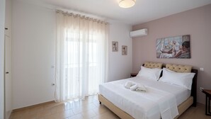 Un dormitorio con cama, cortinas, un cuadro y una lámpara en el techo.