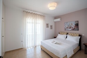 Une chambre à coucher avec un lit, des rideaux, un tableau et un luminaire au plafond.