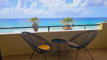Enjoy the ocean view from this balcony with a pair of comfortable chairs and a small table.