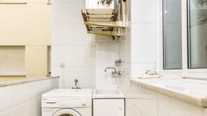 A compact laundry room with a front-loading washing machine, a sink, and a window. - Apartamento en Marbella con vistas laterales al mar 332 (Marbella)