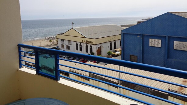 A balcony with a view of the sea, a church, and a blue building. - Apartamento en Marbella con vistas laterales al mar 332 (Marbella)