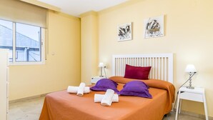 A hotel room with a bed, two bedside tables, a window, and artwork on the wall. - Banana Beach (Marbella)