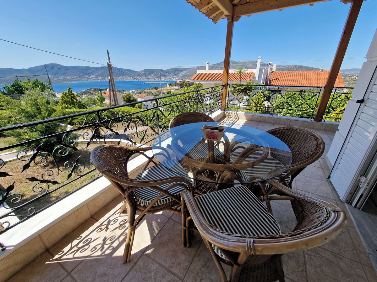 A balcony with wicker furniture and a view of the sea.