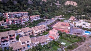 A residential area with multi-story buildings, a swimming pool, and a road. - Corfu Glyfada Menigos Resort 5-8-a (Corfu)
