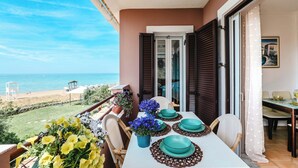 A balcony with a table set for dining, overlooking a beach and the sea. - Corfu Glyfada Menigos Resort 5-8-a (Corfu)