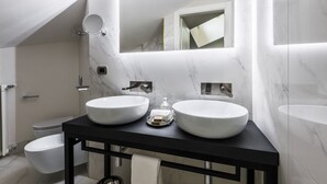 Un baño moderno con dos lavamanos blancos, una encimera negra y un espejo grande.