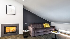 Una sala de estar moderna con chimenea, un sofá y una pequeña mesa.