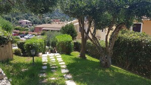 A stone pathway leading to a building surrounded by lush greenery and trees. - Glyfada Apartment Ag3g 129 (Corfu)