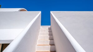 A white staircase leading upwards between two white walls under a clear blue sky. - Air-Conditioned Villa with Sea View, Salty Pool, Terraces & Wi-Fi; Parking Available (Siesta - Santa Eulalia del Río)