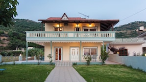 Une maison à deux étages dotée d’un balcon, d’une porte d’entrée et d’un chemin menant à l’entrée.
