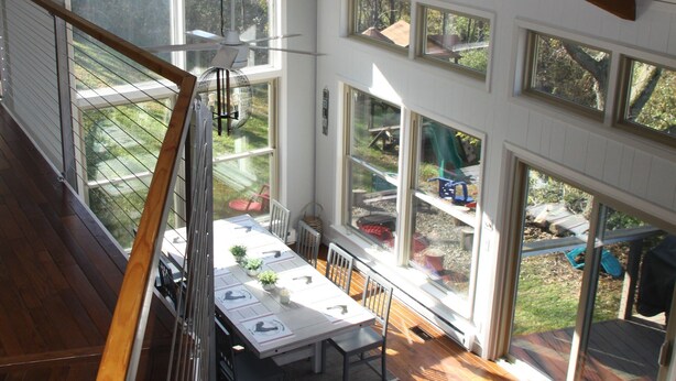 A spacious room with a high ceiling, large windows, and a view of the outdoors. - Modern Home w/private hot tub, game room, & Amazing VIEWS (Galena)