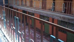 A multi-story building with balconies, railings, and a red floor. - Desmak Hotel (Isiolo)