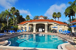 A pool area with a clear blue pool, lounge chairs, and palm trees. - 2.5 Miles to Disney • Pool & Spa • Game Room • 4 King Rooms • Gated Resort (Kissimmee)