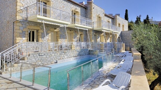 A stone building with a swimming pool and lounge chairs. - Manoleas Villas- Apartment 1 (West Mani)