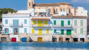 Un edifici costaner amb diversos balcons, una torre i un cos d'aigua al davant.