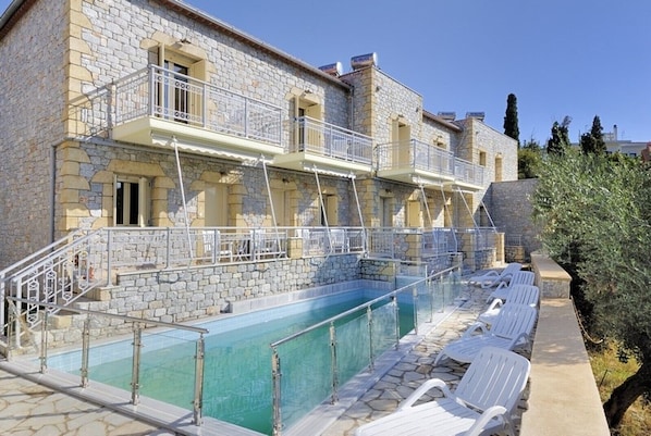 A stone building with a swimming pool and outdoor seating. - Manoleas Villas - Apartment 2 (West Mani)