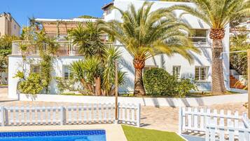 Een buitenzwembad, ligstoelen bij het zwembad