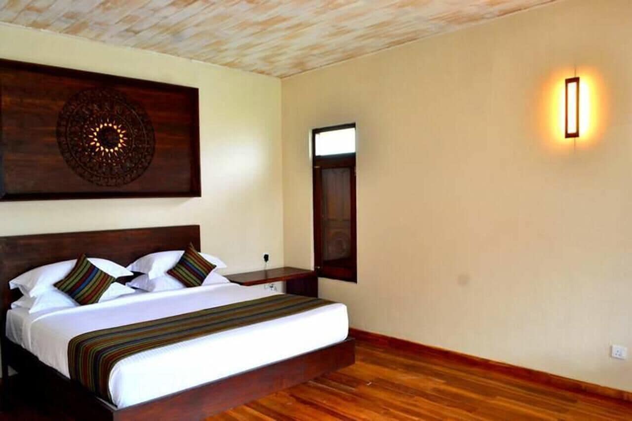 A bedroom with a large bed, a wooden headboard, a wall-mounted light, and a decorative wooden panel above the bed.