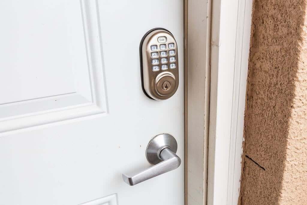 A door with a numeric keypad lock and a lever handle.
