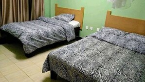 A room with two single beds, each with a zebra-patterned bedspread. - Downhill Springs Resort (Webuye)