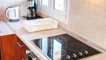 A kitchen with wooden cabinets, a built-in oven, a stovetop, and a window.