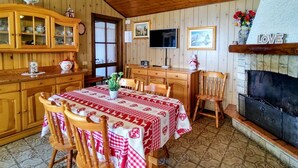 A cozy dining area with a wooden table, chairs, and a fireplace.