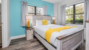 A bedroom with a bed, nightstands, and a window.