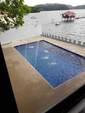 A swimming pool with a view of a lake and a small dock. - Vista Castillo Hotel (Golfito)