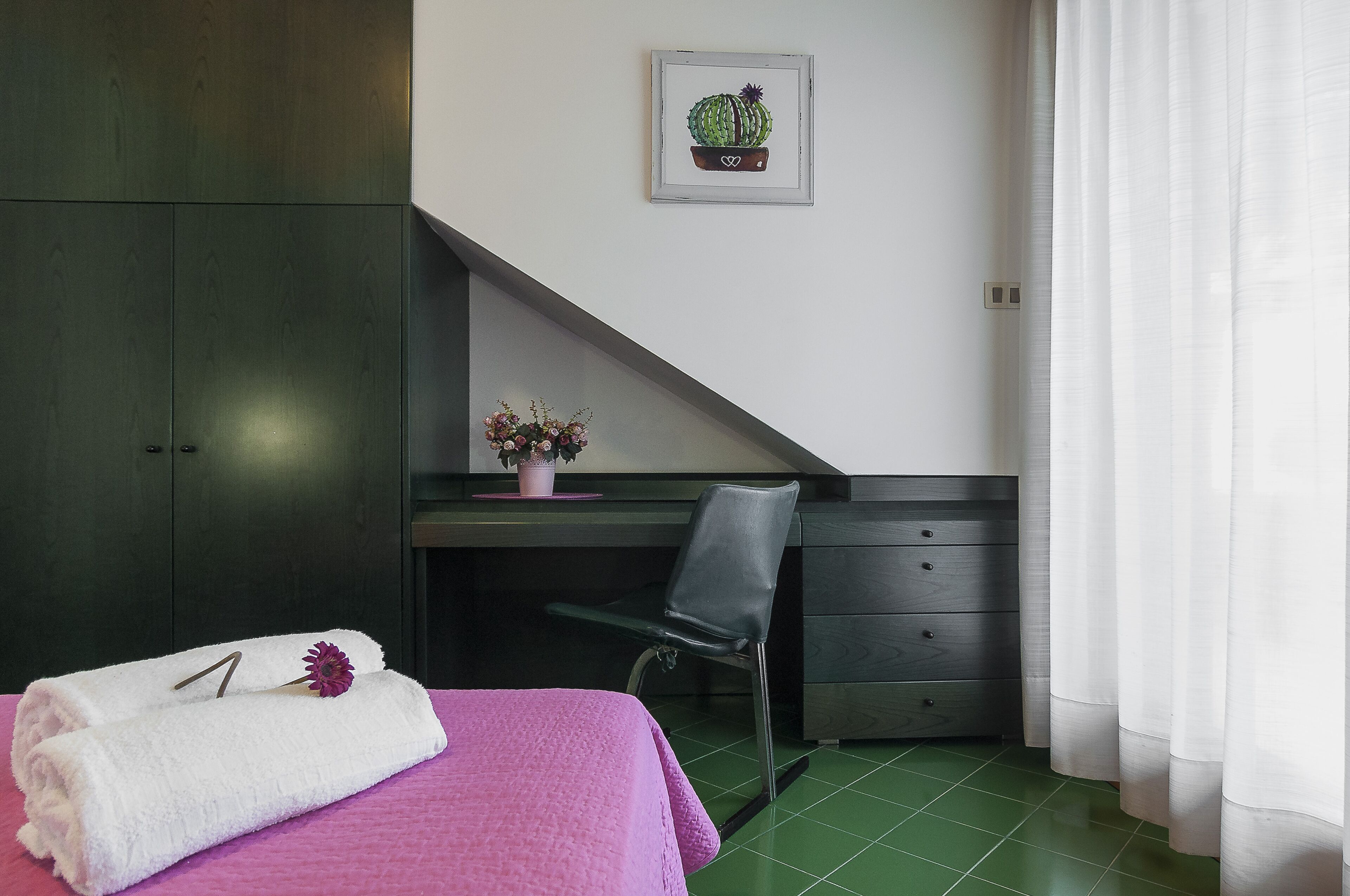Une chambre à coucher avec un lit, un bureau, une chaise et une armoire.