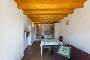 A compact living space with a dining area, kitchenette, and a sofa.