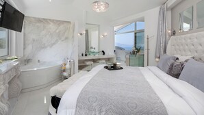 A modern bedroom with a large bed, a bathtub, and a vanity. - Dion Villa Zakynthos Greece One Bedroom Villa With Private Pool No01 (Zakynthos)
