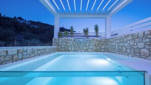 A glass-enclosed infinity pool with a stone wall and a white pergola structure. - Dion Villa Zakynthos Greece One Bedroom Villa With Private Pool No01 (Zakynthos)