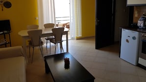 A compact living space with a dining area, a kitchen, and a seating area.