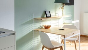 A modern, well-lit room with a desk, chairs, and a hanging lamp.