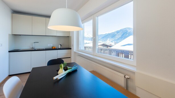 A modern kitchen with a window view of a snowy mountain. - Modern "Hus Apartment - Nr. 5" with Balcony, Garden & Wi-Fi (Olang)