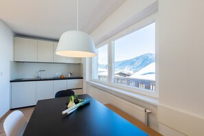 A modern kitchen with a window view of a snowy mountain.