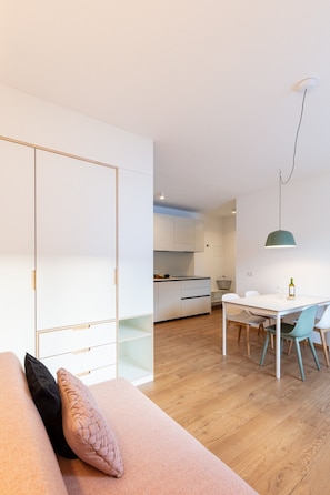 A modern apartment with a living area, kitchenette, and dining space.