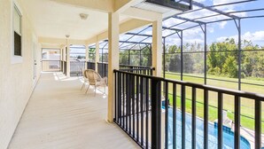 Un espace extérieur abrité comprenant une piscine, une terrasse en bois et une vue sur le paysage environnant.