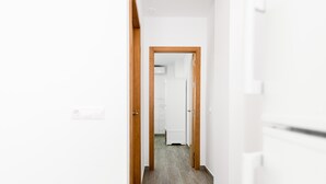 A hallway with wooden doors and a white wall. - Modern studio apartment - La Higuera 2 (Cadiz)