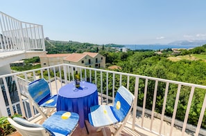 Enjoy a serene view of the surrounding landscape from this balcony with a table and four chairs.