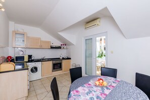 Enjoy meals in the kitchen with washing machine and adjacent dining area with a round table and four chairs.