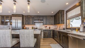 A modern kitchen with wooden cabinets, stainless steel appliances, and a large island with seating.