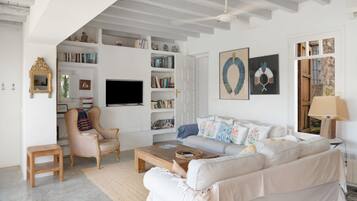 Una sala de estar con sofá, sillón, mesa de centro y estanterías.